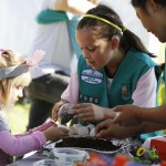 Gabriela Acosta of Girl Scout Troop 2586 helps Ruby Schwerin 4 make a small planter for grass and flower seeds out of an eggshell