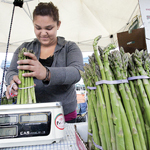 woman weighing asparagus at tracy farmers market